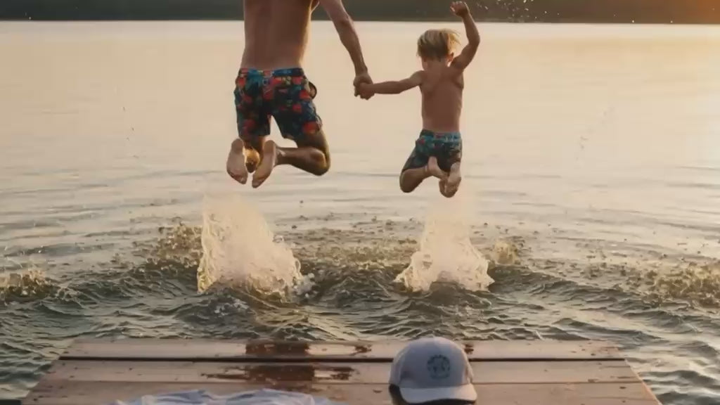 Un père et son fils sautent dans l'eau 