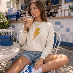 Sweat beige Hey Hey avec motif éclair doré, photographié lors d'un shooting dolce vita