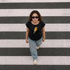 T-shirt noir pour femme à motif éclair, présenté dans une photo d'ambiance décontractée